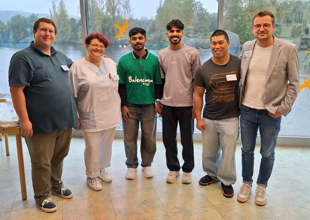 Gruppenfoto von rechts nach links: stellvertretende Pflegedienstleitung Pasqual Fieber, Praxisanleiterin Vera Sokolov, Auszubildener, Auszubildener, Praxisanleiter Sven Effendy, Geschäftsführende Pflegedienstleitung Marco Warnath