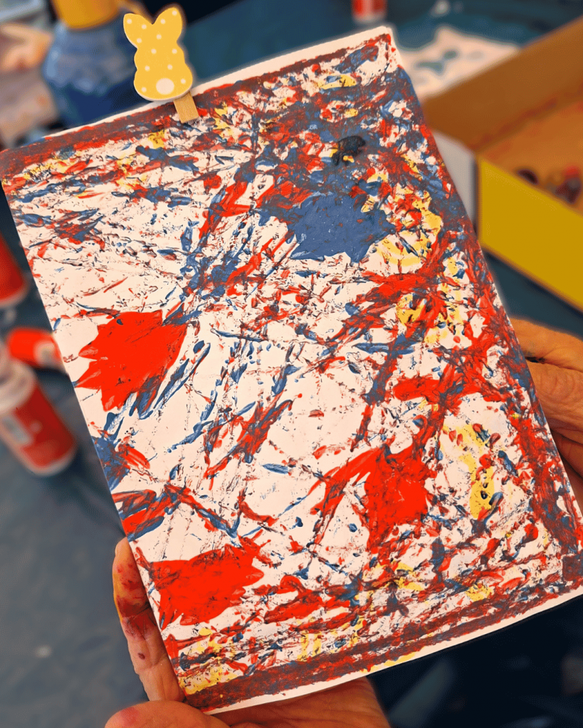 eine abstrakt gemalte Postkarte in rot blauen Farben