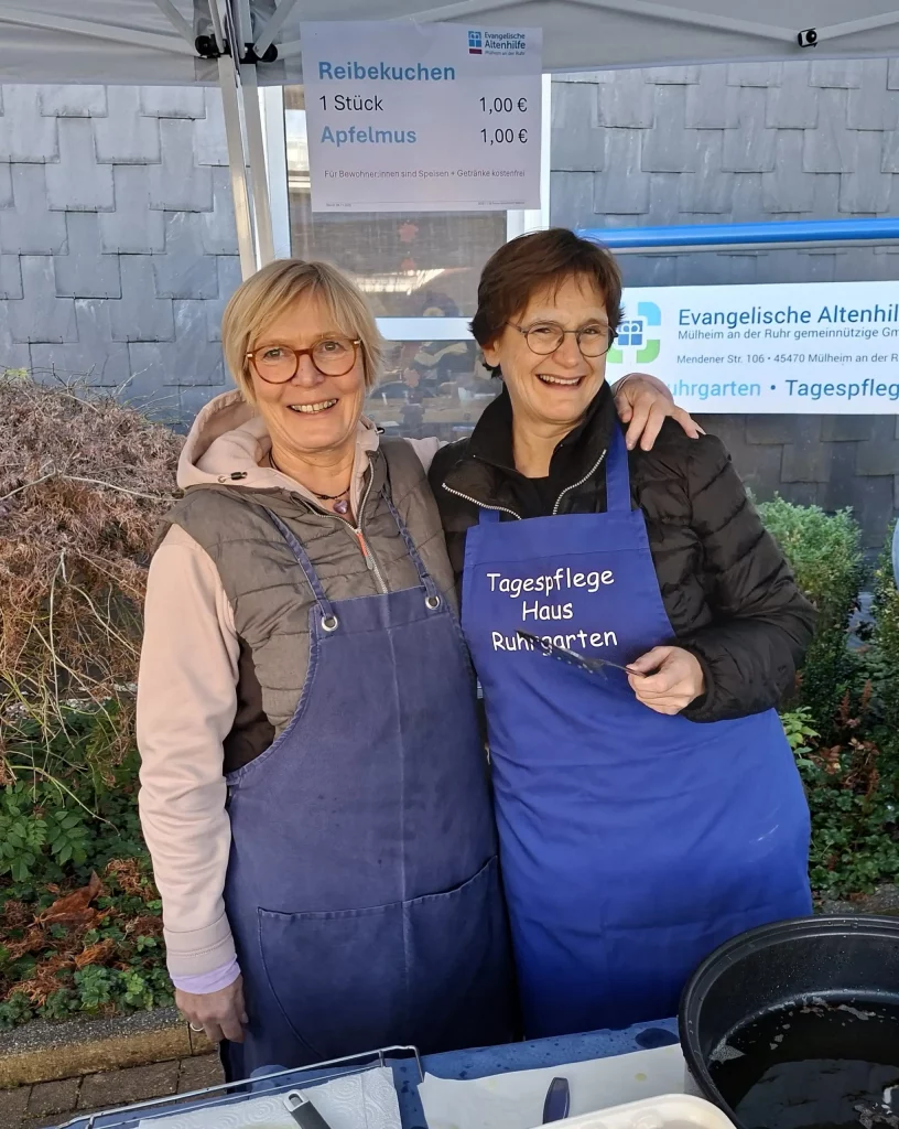 2 lachende Personen, die sich in den Armen halten